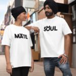 A South Asian couple wearing HinglishWear t-shirts. The girl's shirt reads "Mate" and the boy's shirt reads "Soul," combining to form "Soulmate" when standing together.